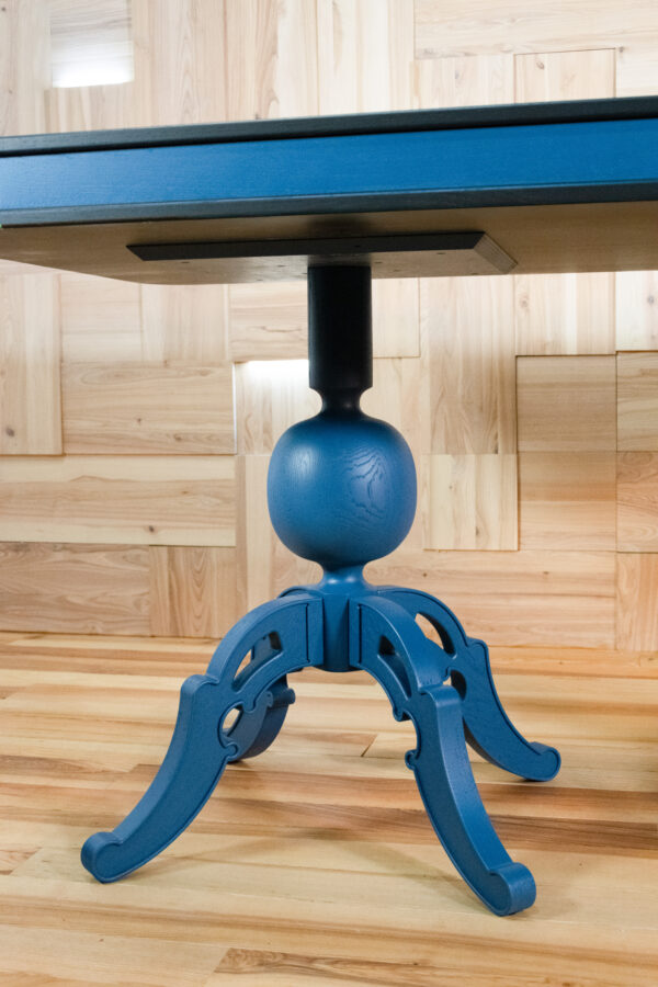 Orlik – designerski stół z czarnym blatem i niebieskimi dekoracyjnymi nogami